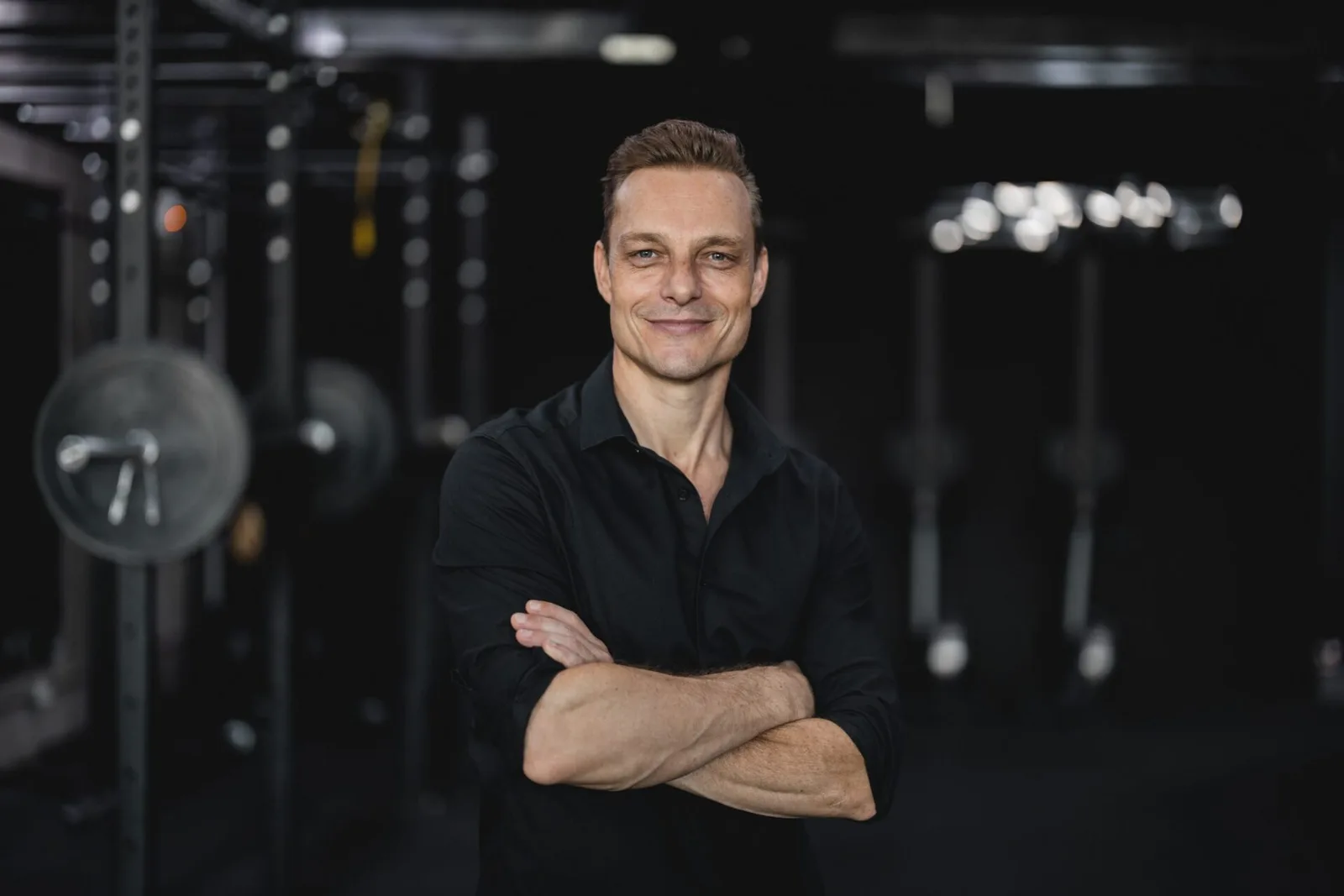 Dan Remon, arms crossed, in a training studio